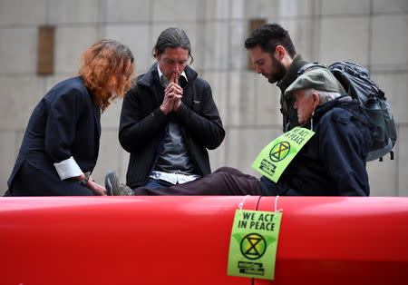 Protesters pray on top of a train block traffic at Canary Wharf Station during the Extinction Rebellion protest in London, Britain April 25, 2019. REUTERS/Dylan Martinez