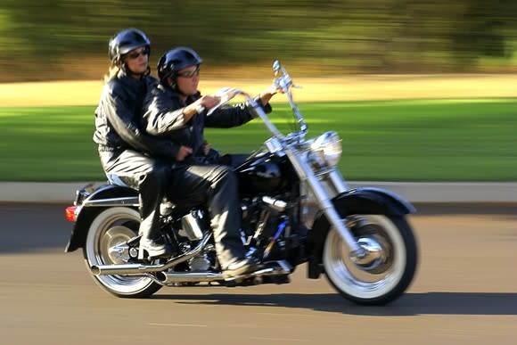 Man and woman riding together on a motorcycle.