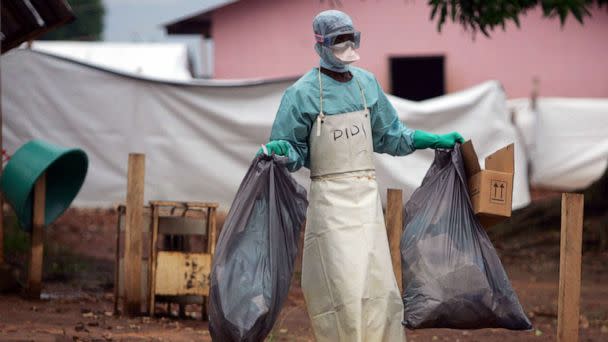 PHOTO: In this April 20, 2005 file photo a health worker in protective clothing carries waste for disposal outside the isolation ward where victims of the deadly Marburg virus are treated in the northern Angolan town of Uige. (Mike Hutchings/Reuters, FILE)