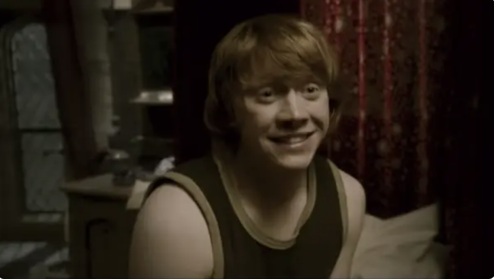 Rupert as Ron smiling in a sleeveless top