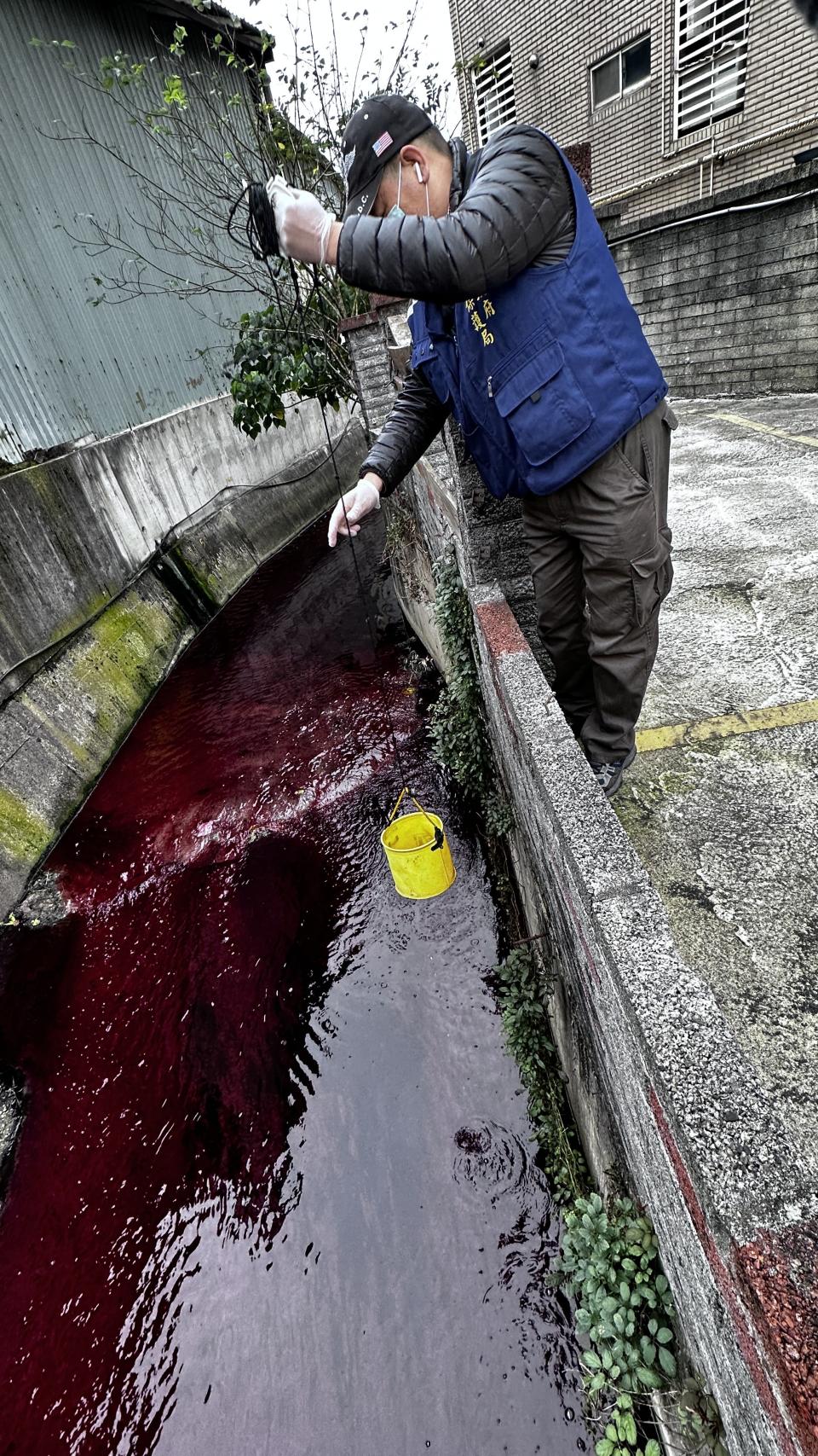 新北環保局稽查人員今15日上午接獲通報，東門溪溝渠遭排放大量紅色廢水。（新北市環保局提供）