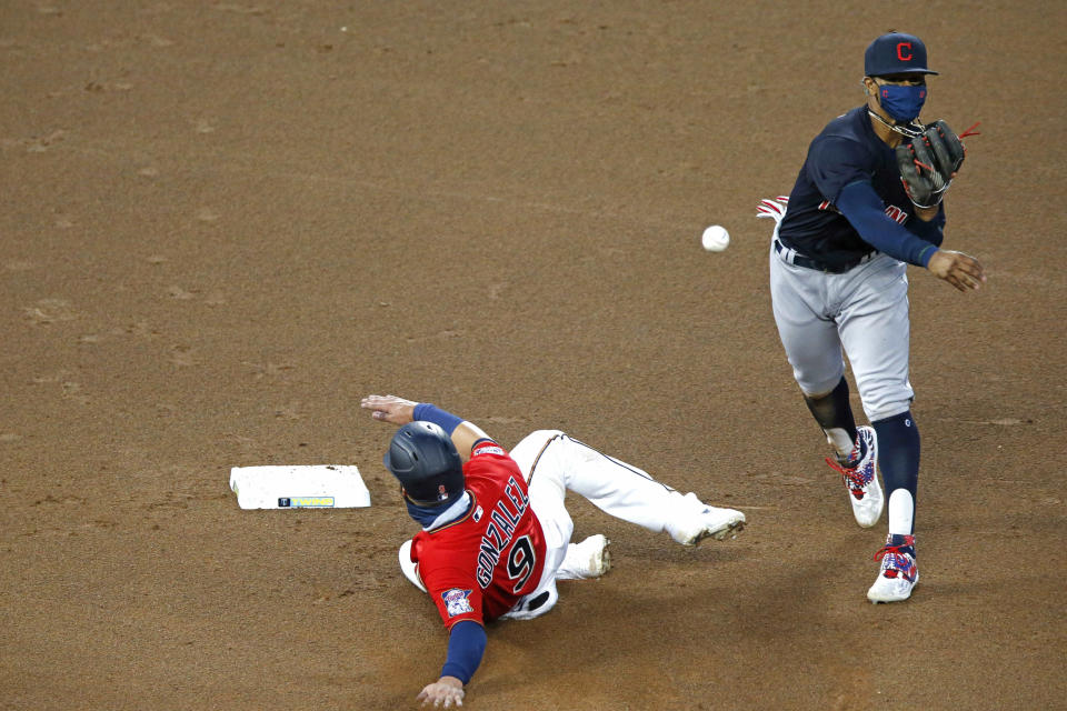 Cleveland Indians shortstop Francisco Lindor, right, throws to first to complete a double play after a force-out at second base of Minnesota Twins' Marwin Gonzalez, left, in the fourth inning of a baseball game Friday, July 31, 2020, in Minneapolis. (AP Photo/Jim Mone)