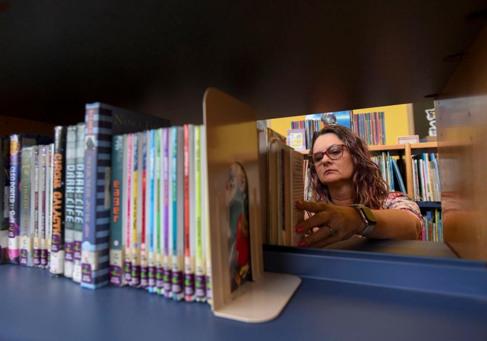 Janie Tausch, a media specialist for Allapattah Flats K-8 School in Port St. Lucie, demonstrates how she organizes the libraries books, Tuesday, Aug. 1, 2023.