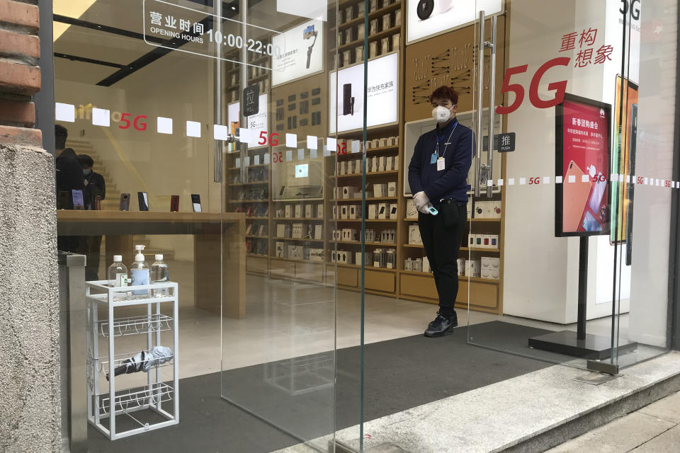 A store employee waits for customers at a re-opened retail street in Wuhan in central China's Hubei province on Monday, March 30, 2020. Shopkeepers in the city at the center of China's virus outbreak were reopening Monday but customers were scarce after authorities lifted more of the anti-virus controls that kept tens of millions of people at home for two months. (AP Photo/Olivia Zhang)