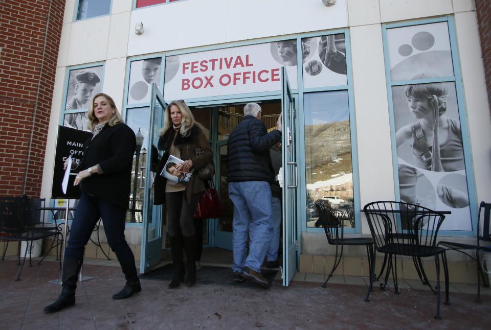 Visitors walk out of an entrance to the 2014 Sundance Film Festival box office on Thursday, Jan. 16, 2014, in Park City, Utah. The independent film festival runs Jan. 16-26, 2014. (Photo by Danny Moloshok/Invision/AP)