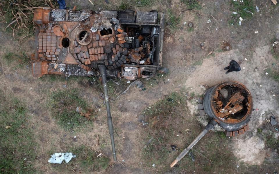 A man passes by Russian tanks destroyed in a recent battle against Ukrainians in the village of Dmytrivka, close to Kyiv - Efrem Lukatsky /AP