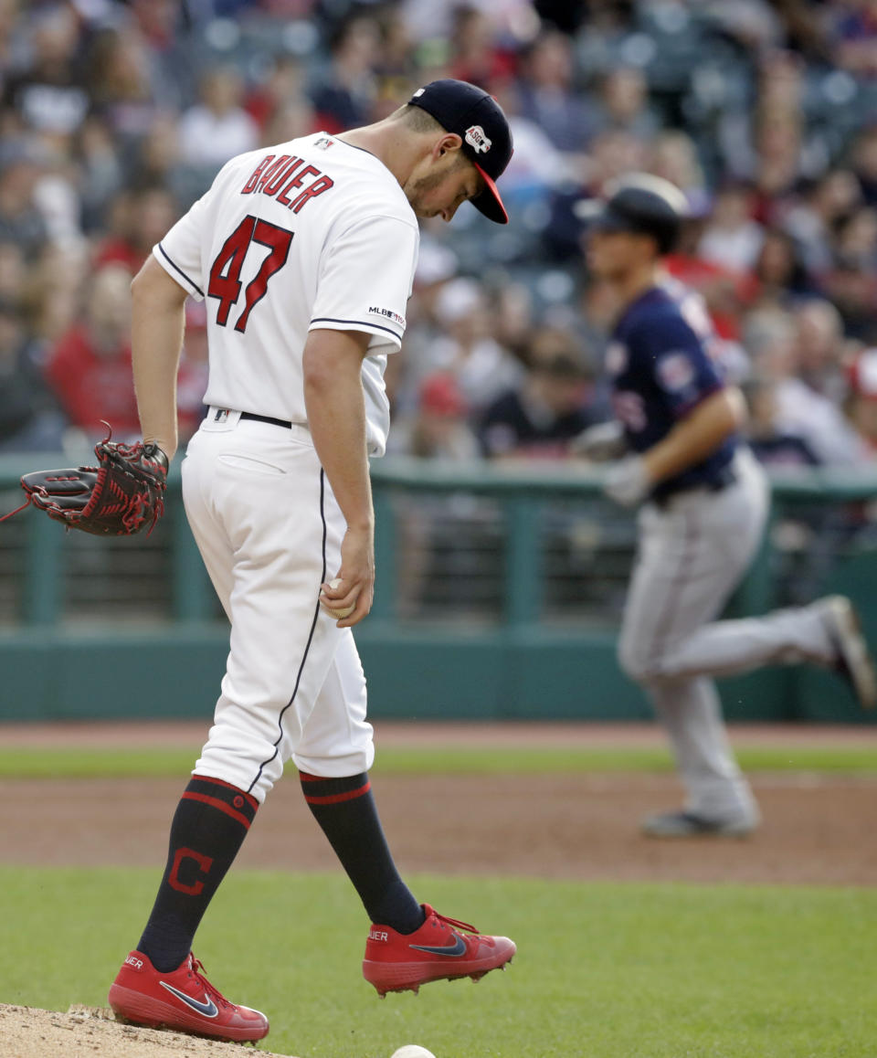 Cleveland Indians starting pitcher Trevor Bauer, left, waits for Minnesota Twins' Max Kepler to run the bases after Kepler hit a two-run home run during the third inning of a baseball game Thursday, June 6, 2019, in Cleveland. (AP Photo/Tony Dejak)