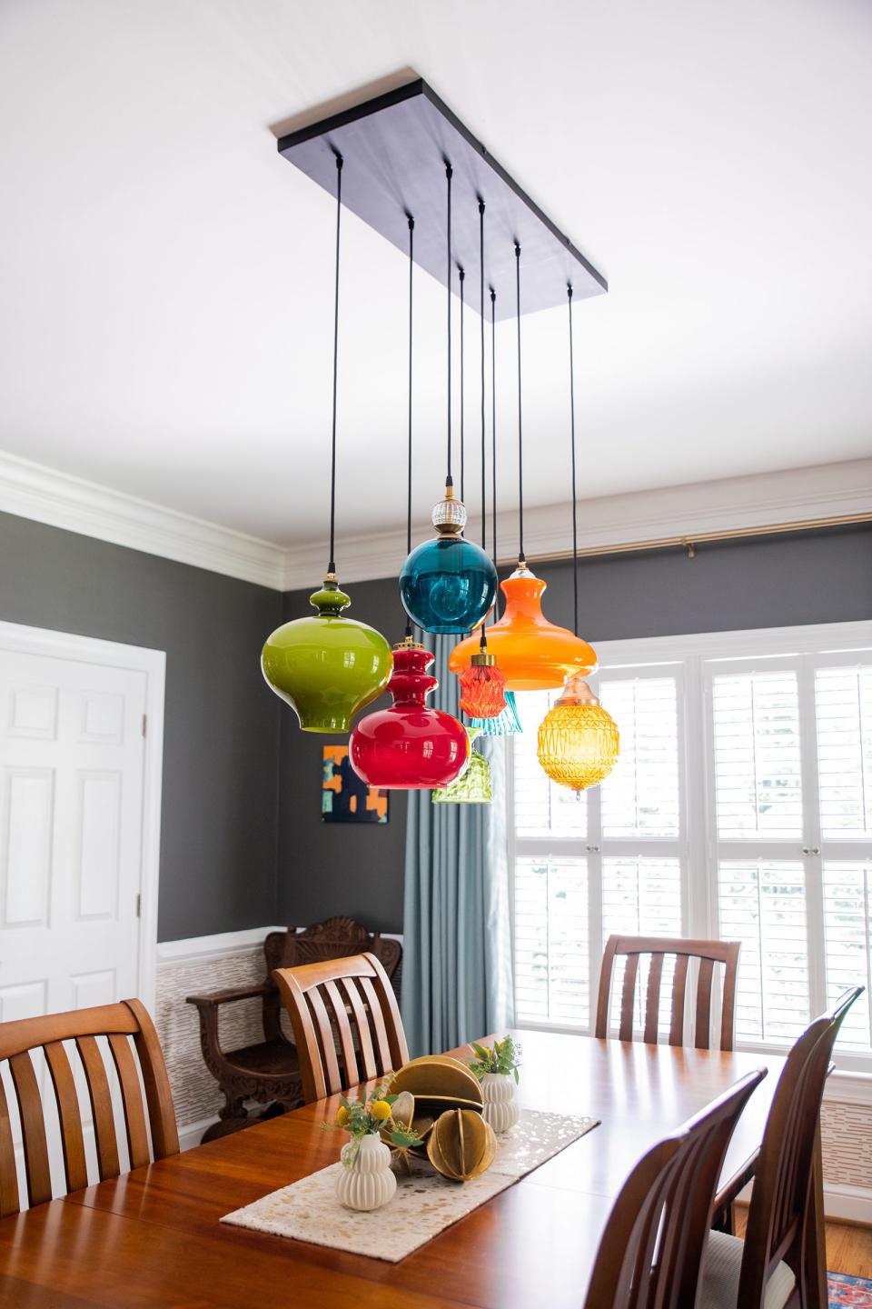 Serving as the focal point of the dining room, a custom-made light fixture was assembled using vintage colored glass pendants, resulting in a one-of-a-kind showpiece.