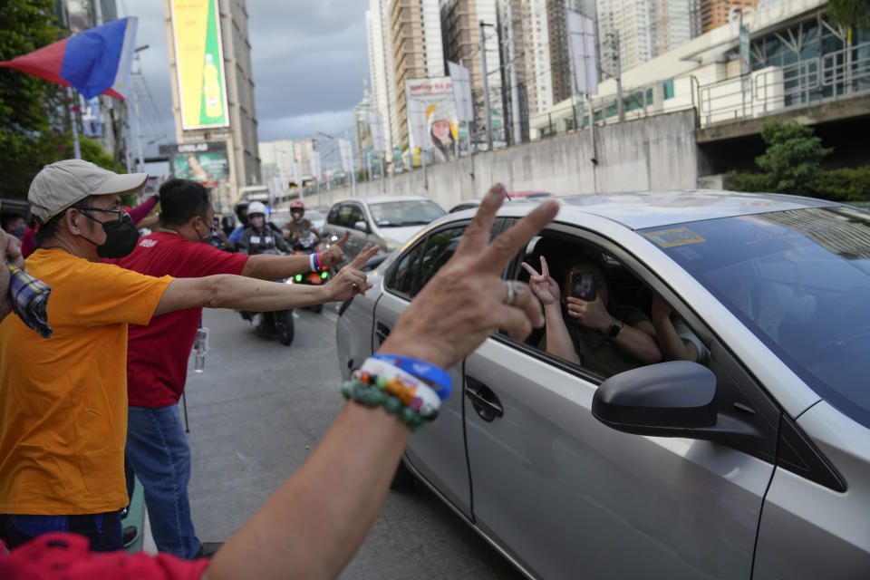 Supporters of Ferdinand 'Bongbong' Marcos Jr. flash the victory sign as they celebrate along a street in Mandaluyong, Philippines on Tuesday May 10, 2022. Marcos Jr.'s apparent landslide victory in the Philippine presidential election is giving rise to immediate concerns about a further erosion of democracy in the region, and could complicate American efforts to blunt growing Chinese influence and power in the Pacific. (AP Photo/Aaron Favila)