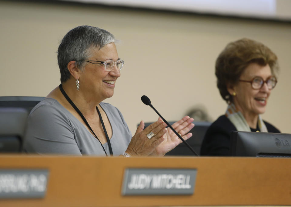 FILE - In this Sept. 25, 2015, file photo, Mary Nichols, left, chair of the California Air Resources Board, applauds after the board restored ambitious rules to cut transportation fuel emissions 10 percent within five years, during a hearing in Sacramento, Calif. Nichols' term leading the board ends in December. She's held the role since 2007 after an earlier stint as chair in the early 1980s. (AP Photo/Rich Pedroncelli, File)
