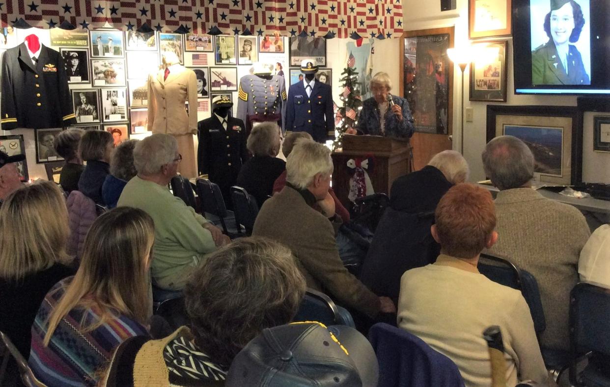 Dorothy Managan, (at podium) shares her stories and a photo of herself in uniform during a program at the Veterans History Museum.