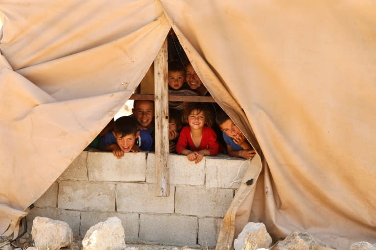 Palestinian children look out from a window in the Palestinian village of Khirbet Zanuta, located in the hills south of the West Bank city of Hebron