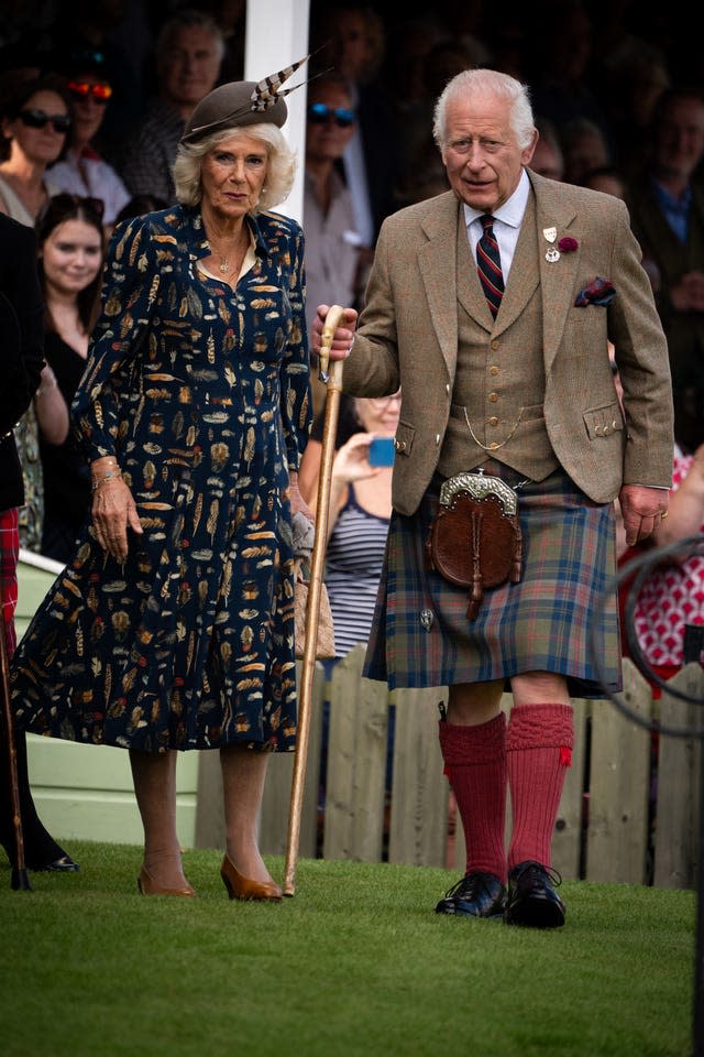 Camilla accompanies Charles as he walks while holding a cane in his right hand