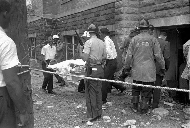 Firefighters and ambulance attendants remove a covered body from the 16th Street Baptist Church in Birmingham, Ala., after a deadly explosion detonated by members of the Ku Klux Klan during services on Sept. 15, 1963. Threats against Black institutions are deeply rooted in U.S. history and leaders say the history of violence against people of color should be passed on to new generations so the lessons of the past can be applied to the present.