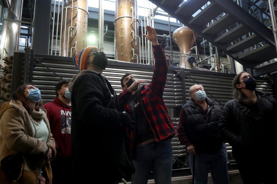 Guide Andrew Huffman (center) talks with guests Jan. 15 during a tour of the Middle West Spirits distillery.