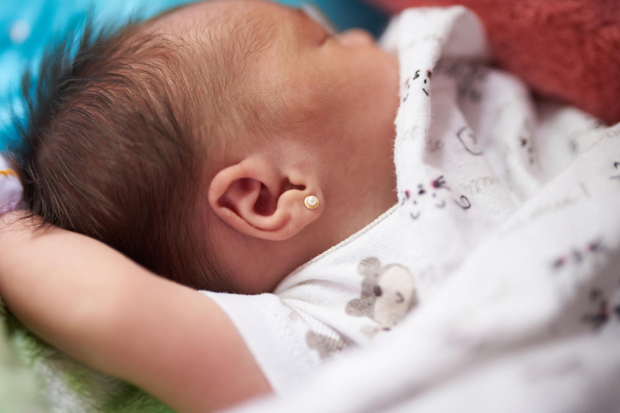 Newborn baby with earring close up view sleeping