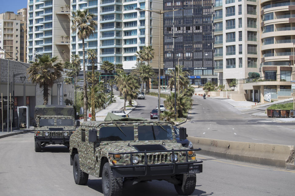 Lebanese army vehicles patrol the streets urging people to stay home unless they have to leave for an emergency in an effort to prevent the spread of coronavirus, in Beirut, Lebanon, Sunday, March 22, 2020. (AP Photo/Hassan Ammar)