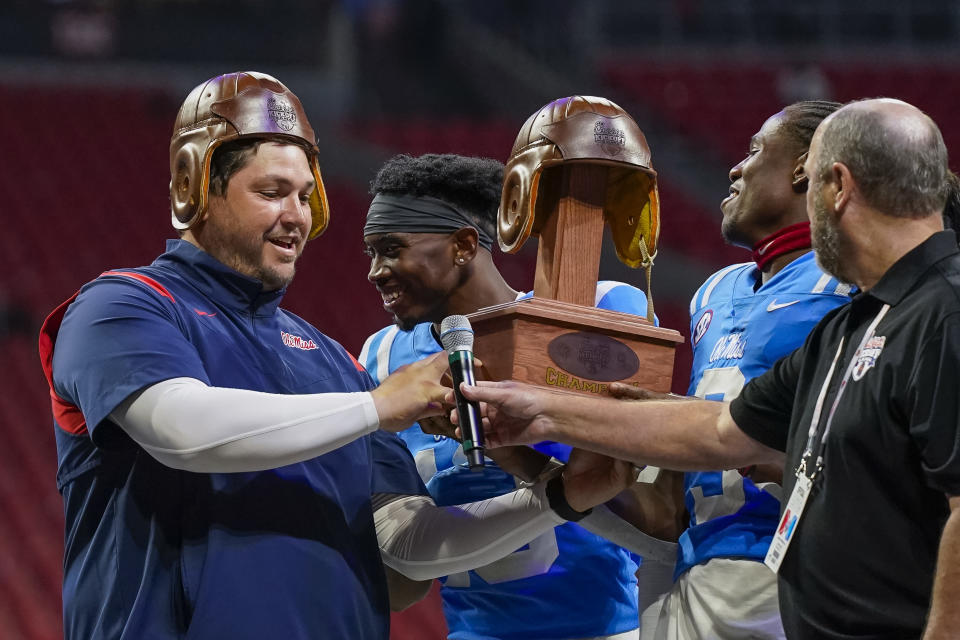 Sept. 6, 2021; Atlanta, Georgia; Mississippi Rebels offensive coordinator Jeff Lebby and the players hold up the old leather helmet after winning the Chick-fil-A Kickoff game against the Louisville Cardinals at Mercedes-Benz Stadium. Dale Zanine-USA TODAY Sports