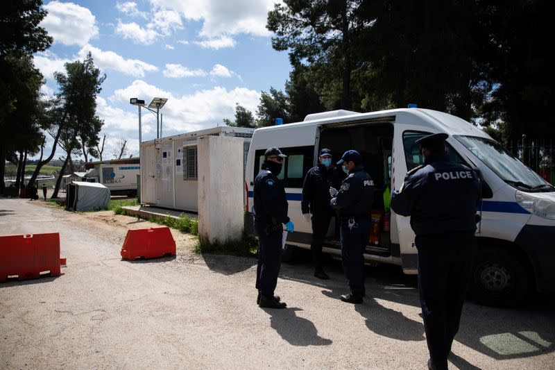 Police officers wearing protective face masks secure the entrance of the Ritsona migrant camp after authorities found 20 coronavirus cases and placed the camp under quarantine, following the outbreak of coronavirus disease (COVID-19), in Ritsona