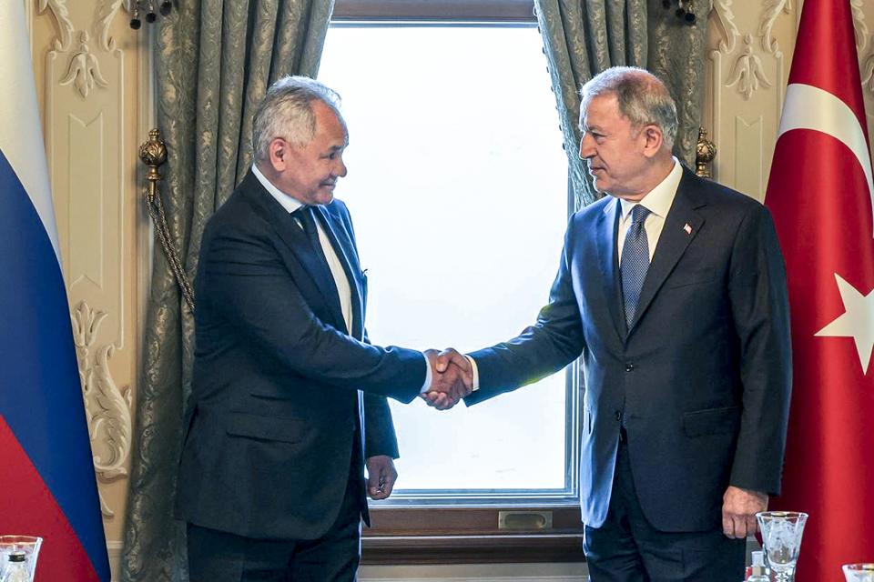 In this handout photo released by Russian Defense Ministry Press Service, Russian Defense Minister Sergei Shoigu, left, and Turkish Defense Minister Hulusi Akar shake hands during their meeting in Istanbul, Turkey, Friday, July 22, 2022. U.N. Secretary General Antonio Guterres and Turkish President Recep Tayyip Erdogan were due on Friday to oversee the signing of a key agreement that would allow Ukraine to resume its shipment of grain from the Black Sea to world markets and for Russia to export grain and fertilizers, ending a standoff that has threatened world food security. (Vadim Savitsky, Russian Defense Ministry Press Service via AP)