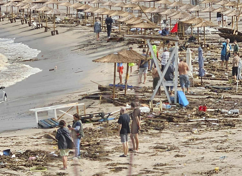 People observe the damage on the beach, after a storm, in Arapya, Bulgaria, Tuesday, Sept. 5, 2023. Bulgaria's Prime Minister Nikolay Denkov said two people died and three others were missing after a storm caused floods on the country's southern Black Sea coast. (AP Photo/Milena Genadieva)