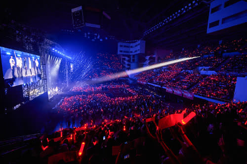 Fans holding up slogans, painted red by the bright Konbat lightsticks (iKON's official lightstick).