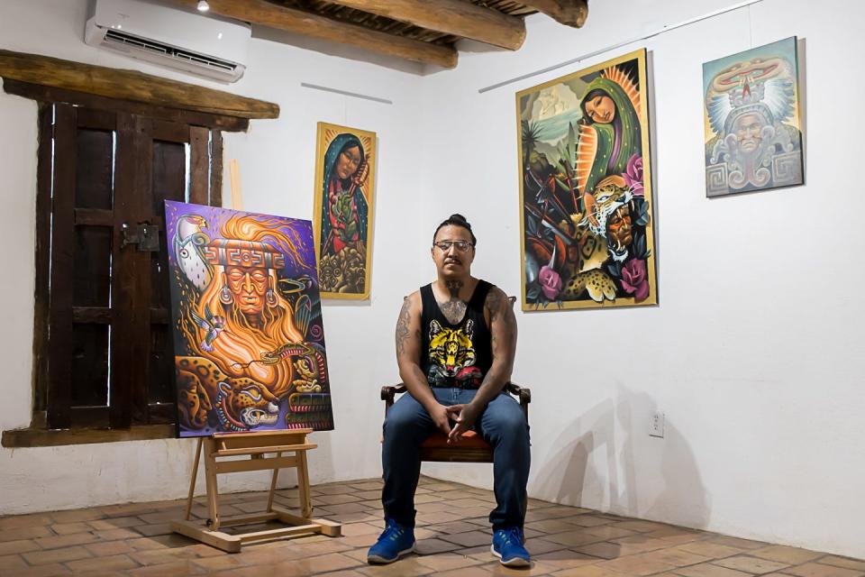 Painter and tattoo artist Pablo Hernandez is shown with some of his work at a previous art exhibit.