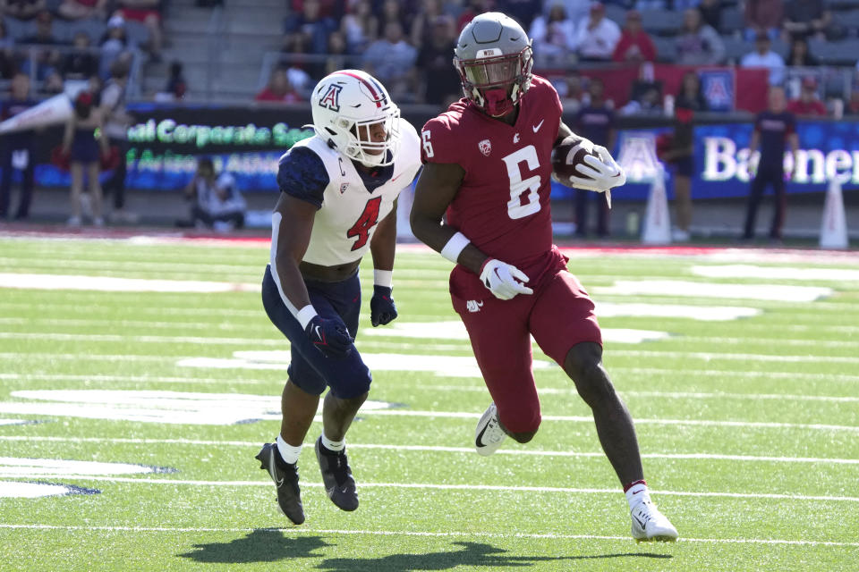 Washington State wide receiver Donovan Ollie (6) tries to run away from Arizona cornerback Christian Roland-Wallace in the first half during an NCAA college football game, Saturday, Nov. 19, 2022, in Tucson, Ariz. (AP Photo/Rick Scuteri)