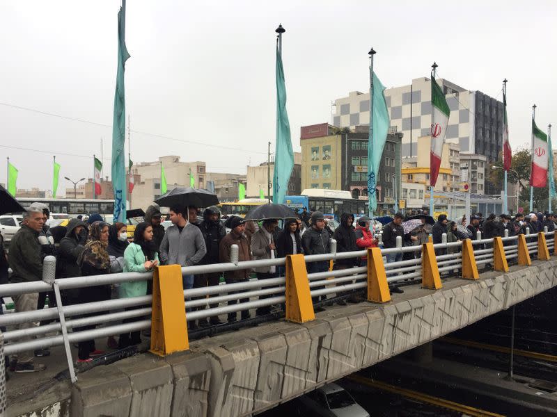 FILE PHOTO: People stands in the street to show their protest against increased gas price in Tehran