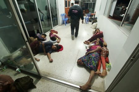 Rohingya people are seen detained in a police station after a fishing boat carrying more than sixty Rohingya refugees was found beached at Rawi island