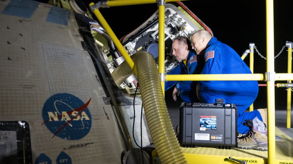 NASA astronauts Mike Fincke, left, and Scott Tingle look inside NASA's Boeing Crew Flight Test Starliner spacecraft after it landed uncrewed at White Sands Missile Range’s Space Harbor, in New Mexico, on September 7. - Aubrey Gemignani/NASA