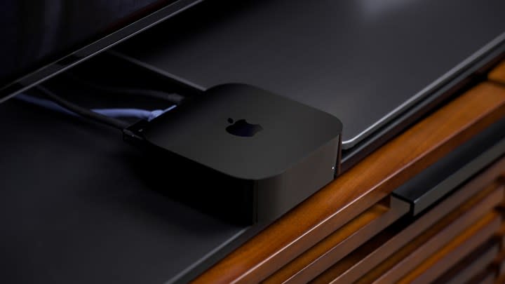 An Apple TV 4K box on a media console. 
