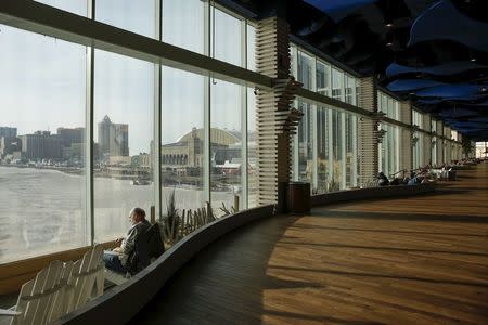 A man looks at the ocean through the windows of the Playground Pier, a luxury shopping mall, in Atlantic City, New Jersey January 20, 2016. REUTERS/Shannon Stapleton