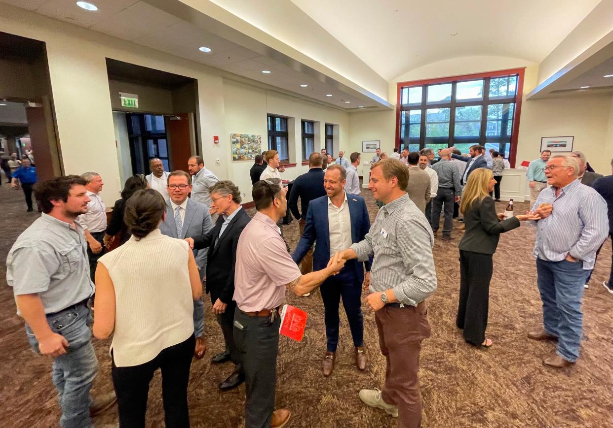 People mingle in the second floor lobby following NAI TALCOR's Market Update Event at the Turnbull Center on Monday, March 25, 2024.