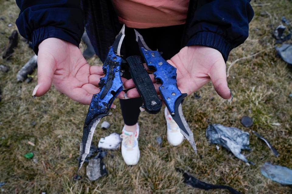 Sarah Cooper, 26, of Clinton Township holds what is thought to be knives that were part of the debris left from multiple explosions on Tuesday, Mar. 5, 2024 that occurred last night at the Select Distributors in Clinton Township at 15 Mile Road.