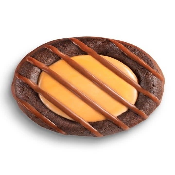 Promotional image of Adventurefuls close up, with a creamy-looking cararmel center, brownie-like cookie, and stripes of chocolate drizzled on top