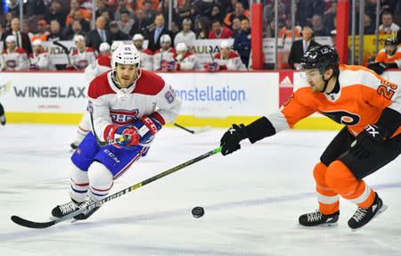 Mar 19, 2019; Philadelphia, PA, USA; Montreal Canadiens right wing Andrew Shaw (65) flips the puck past Philadelphia Flyers left wing James van Riemsdyk (25) during the first period at Wells Fargo Center. Mandatory Credit: Eric Hartline-USA TODAY Sports