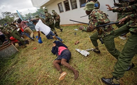 Supporters of President Uhuru Kenyatta engage in rock-throwing clashes with police at his inauguration ceremony after trying to storm through gates - Credit: Ben Curtis/ AP