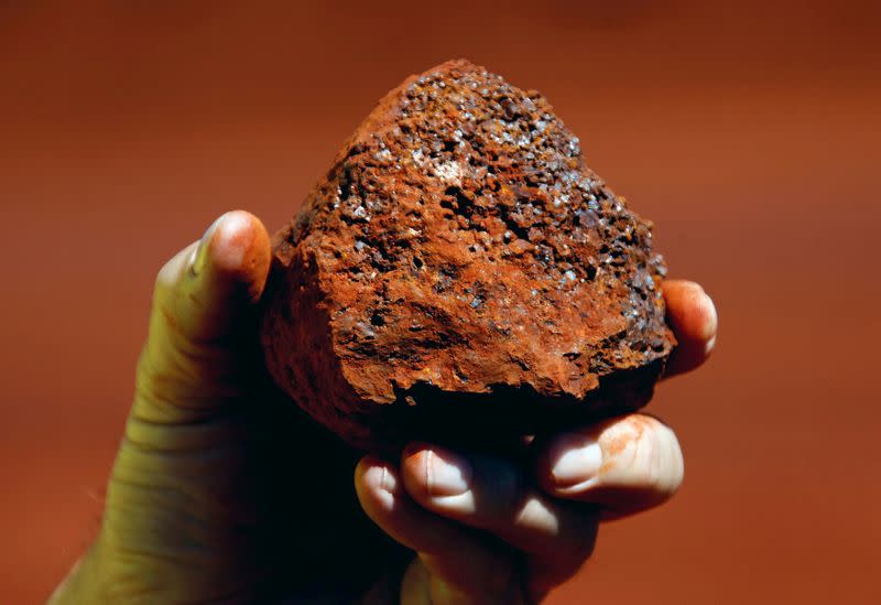 FILE PHOTO: File photo of a miner holding a lump of iron ore at a mine located in the Pilbara region of Western Australia