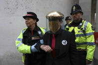 Police remove a Extinction Rebellion climate protester after they formed a line and glued themselves to the entrances of the London Stock Exchange in the City of London, Thursday April 25, 2019. (Isabel Infantes/PA via AP)