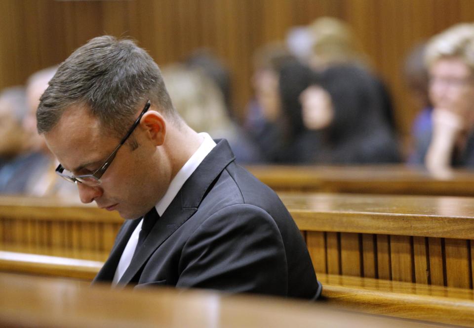 Oscar Pistorius sits in the dock in court in Pretoria, South Africa, Friday, March 14, 2014 prior to the tenth day of his murder trial proceedings. Pistorius is charged with the shooting death of his girlfriend Reeva Steenkamp, on Valentines Day in 2013. (AP Photo/Kim Ludbrook, Pool)
