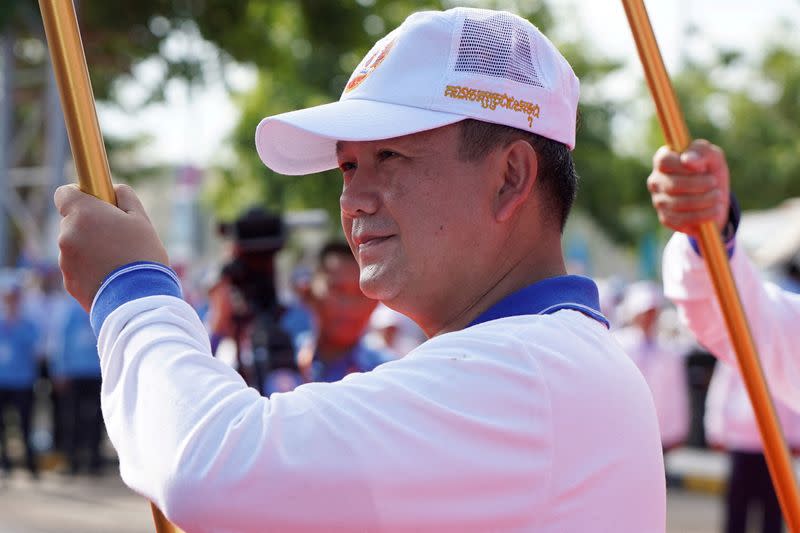 General Hun Manet, son of Cambodia's Prime Minister Hun Sen holds a party flag as he attends a kick-off of an election campaign rally for the upcoming national election in Phnom Penh