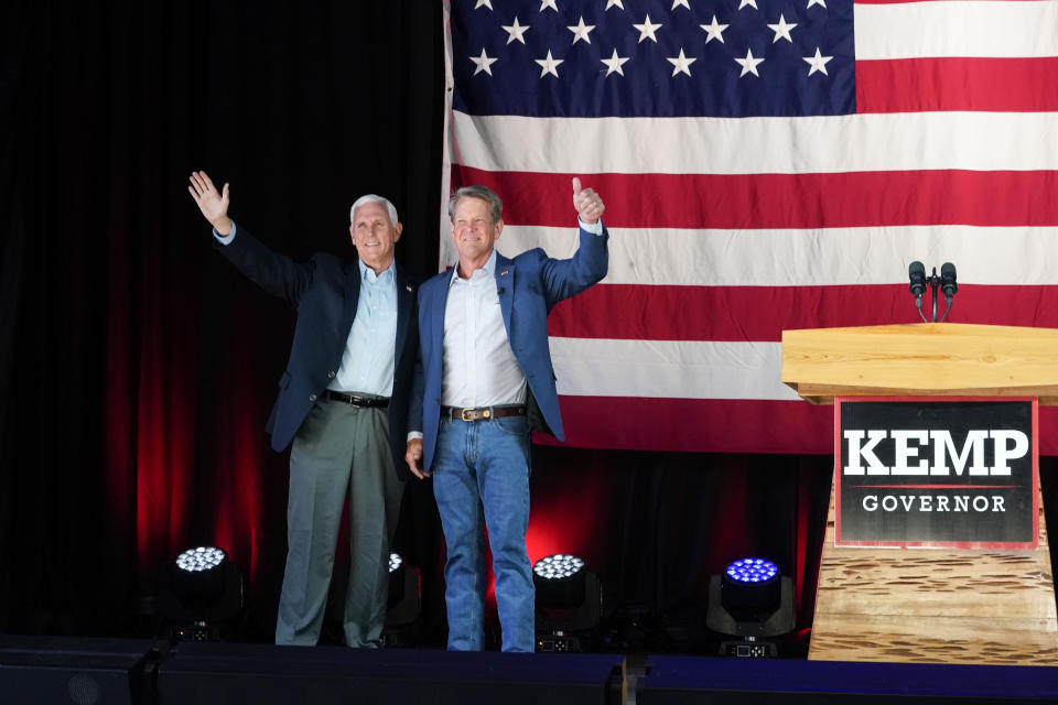 Former Vice President Mike Pence, left, and Georgia Gov. Brian Kemp greet the crowd during a rally, Monday, May 23, 2022, in Kennesaw, Ga. Pence is opposing former President Donald Trump and his preferred Republican candidate for Georgia governor, former U.S. Sen. David Perdue. (AP Photo/Brynn Anderson)