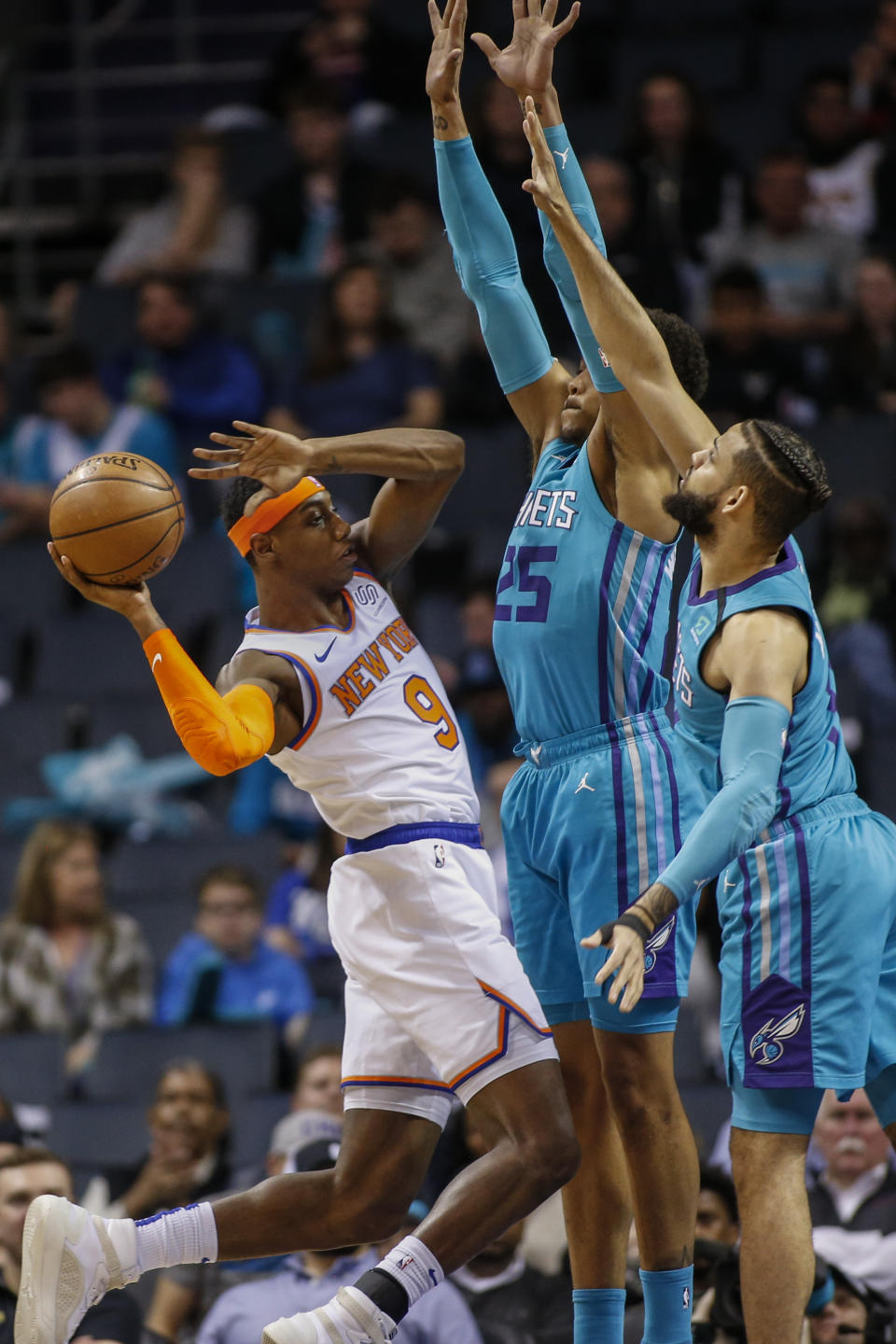 New York Knicks guard RJ Barrett, left, tries to pass the ball around Charlotte Hornets forwards P.J. Washington and Cody Martin, right, during the first half of an NBA basketball game in Charlotte, N.C., Wednesday, Feb. 26, 2020. (AP Photo/Nell Redmond)