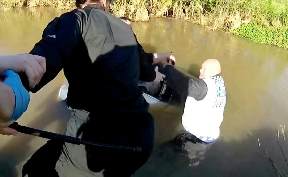 As the woman was in immediate danger, officers acted quickly to rescue her and formed a human chain to drag her out of a smashed window. (SWNS)