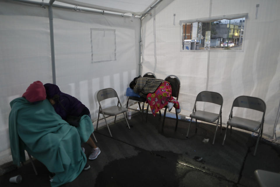 Varias personas duerme en sillas bajo una carpa establecida en la banqueta afuera de un hospital el jueves 7 de mayo de 2020, en la que aguardan noticias de sus seres queridos en Iztapalapa, en la Ciudad de México. (AP Foto/Rebecca Blackwell)