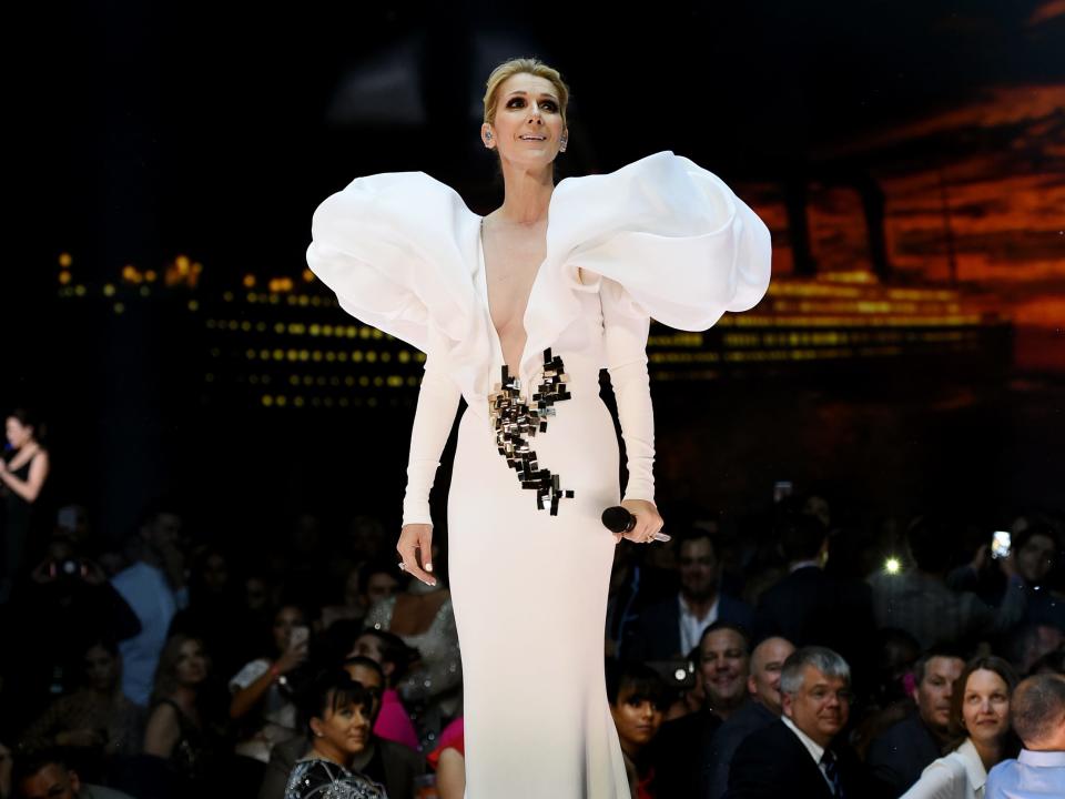Celine Dion wears a white gown to perform at the 2017 Billboard Music Awards.