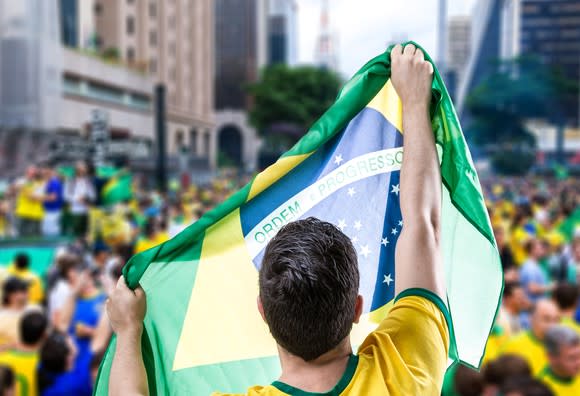 A man holding the Brazilian flag.