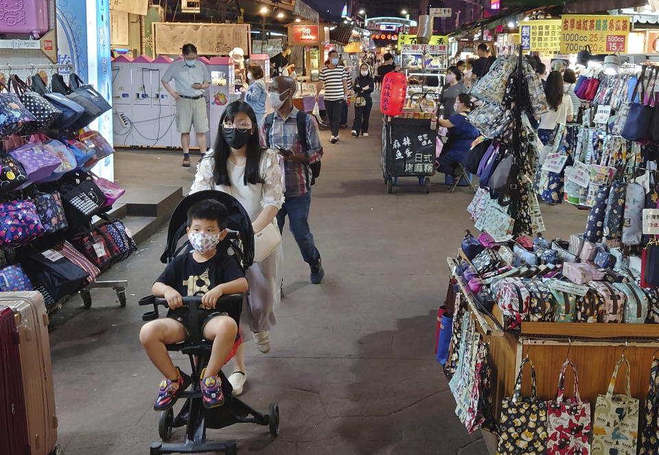 People wear face masks to protect against the spread of the coronavirus at a night market in Taipei, Taiwan, Friday, May 14, 2021. (AP Photo/Chiang Ying-ying)