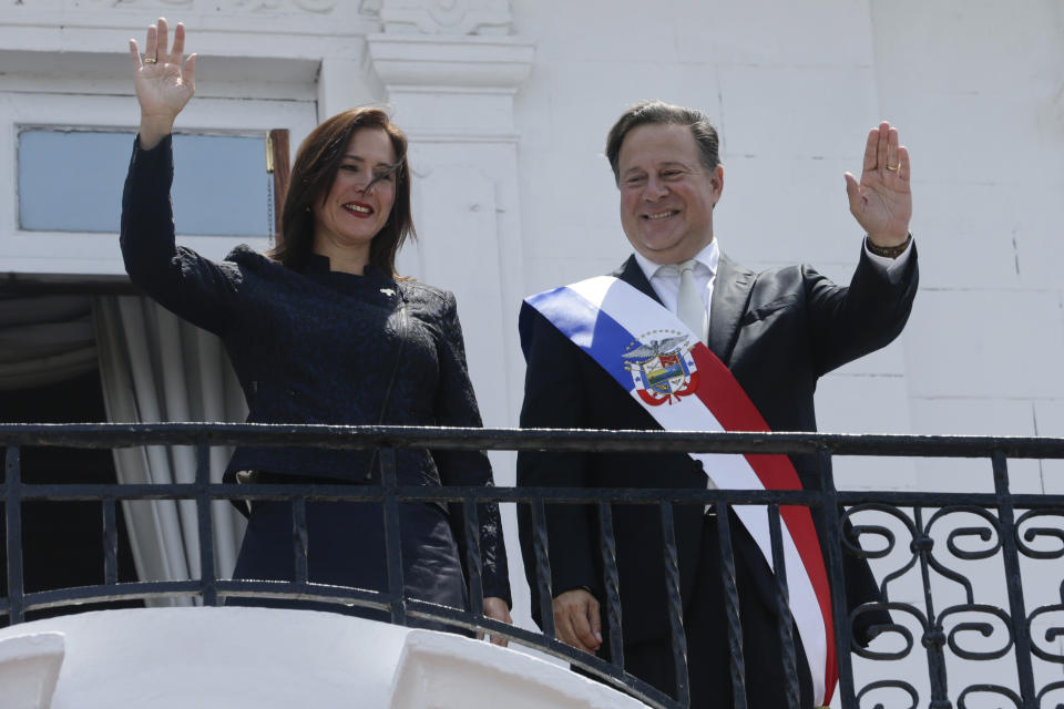 Fabiola Zavarce, left, who was named Venezuela's new ambassador to Panama by self-proclaimed interim president of Venezuela Juan Guaido, waves alongside Panamanian President Juan Carlos Varela during a photo opportunity at the presidential palace in Panama City, Monday, March 18, 2019. In a symbolic ceremony, Zavarce presented her credentials as Venezuela's new ambassador to Panama. (AP Photo/Arnulfo Franco)